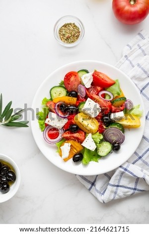 Overhead view of Greek salad on light surface mediterranean food