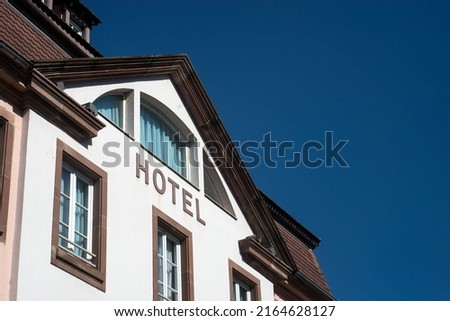 Closeup of 
Hotel sign on building facade in the street on blue sky background