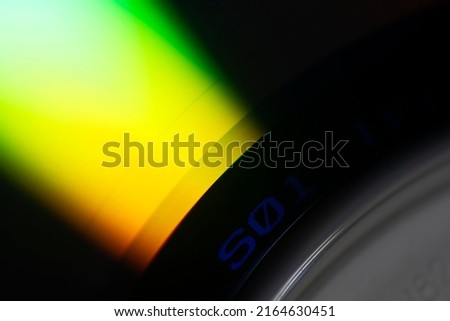 Light uncovered on DVD surface, obsolete technology, color detail on technological surface.
