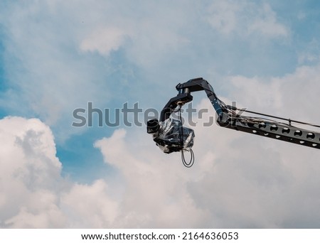 Professional camera mounted on a crane. Organization of video shooting. The camera is mounted at a height. Professional videography of the event.