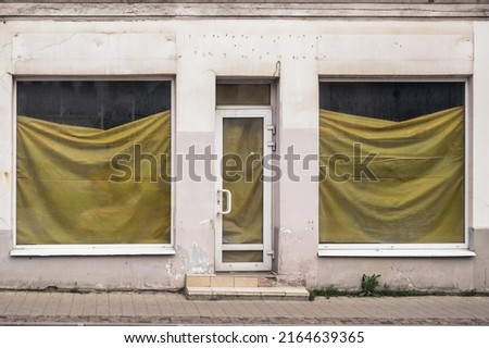 a bankrupt store with film-covered windows. Empty store front economic crisis. closed shop. Royalty-Free Stock Photo #2164639365