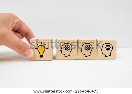 Concept creative idea and innovation. Hand picked wooden cube block with head human symbol and light bulb icon Royalty-Free Stock Photo #2164646473