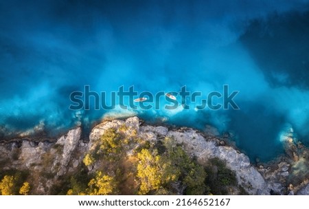 Aerial view of people on floating kayaks on blue sea, rocky coast, trees at sunset in summer. Blue lagoon, Oludeniz, Turkey. Tropical landscape. Sup boards on clear water. Top view of canoe. Tourism Royalty-Free Stock Photo #2164652167