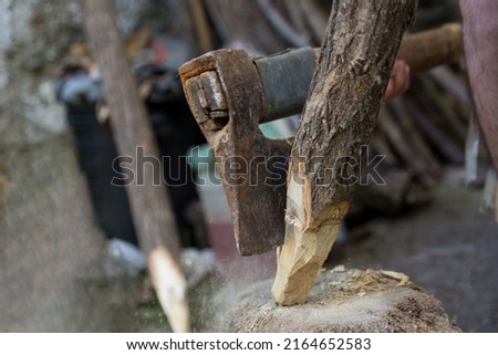 Ax cutting wooden stake outdoor in village yard. Close up, selective focus Royalty-Free Stock Photo #2164652583