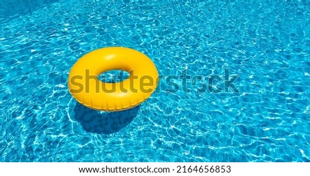 Yellow ring floating in blue swimming pool. Inflatable ring, rest concept Royalty-Free Stock Photo #2164656853