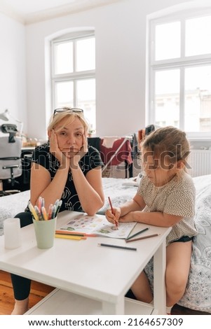Mature woman granny with grandchild preschool girl drawing together at home. 