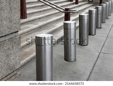 Silver bollards along the road for pedestrian safety
