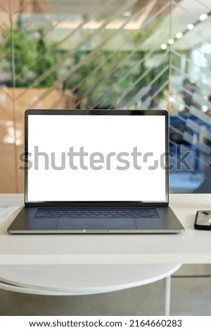 Workplace with laptop pc computer and cellphone on desk with blank white empty mockup screen for advertising in modern contemporary office. No people. Business concept. Vertical. Royalty-Free Stock Photo #2164660283