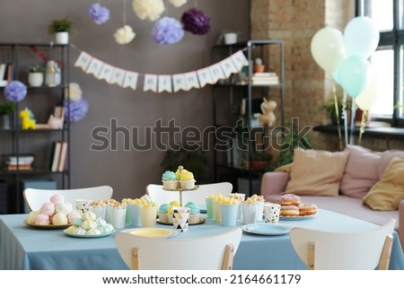 Horizontal image of candy bar on table with cupcakes, donuts, sweets preparing for birthday party at home