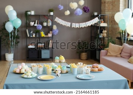 Image of holiday table served with desserts, cupcakes, donuts and other sweets preparing for birthday party at home