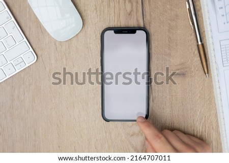 Businessman hand touching screen on modern smartphone. Close-up image with focus on finger