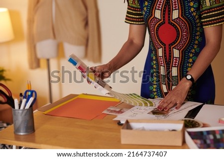 Cropped image of fashion designer choosing color palette for new collection