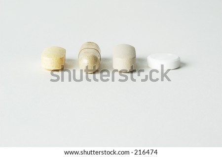 Four different shaped pills in a row
