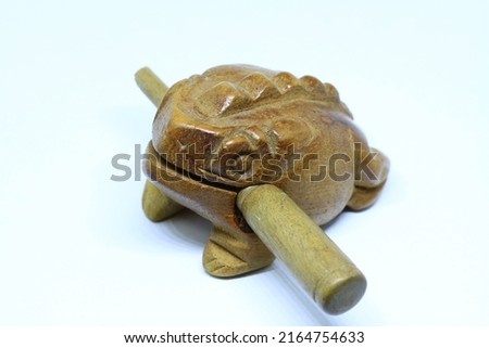 Handcrafted brown wooden toad on a white background.