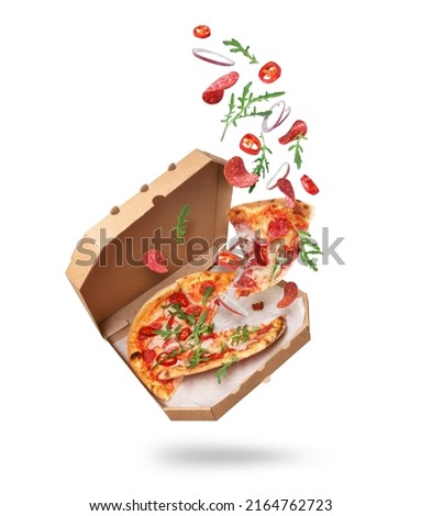 Freshly baked spicy pizza with ingredients in the air isolated on a white background