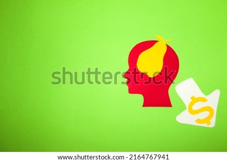 red head with a paper pear in it and an arrow down next to it, creative thinking about falling food prices, green background