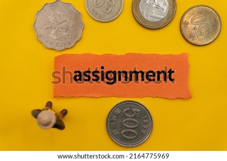 assignment.The word is written on a slip of paper,on colored background. professional terms of finance, business words, economic phrases. concept of economy.