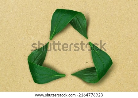 Recycling symbol made of leaves on recycled paper background - Concept of ecology and recycling