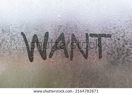 The word want written on the sweaty glass of the window