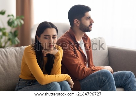 Marital Crisis. Unhappy Arabic Couple Sitting On Couch At Home, Having Relationship Problems. Bad Marriage, Breakup Concept. Selective Focus On Frustrated Woman Royalty-Free Stock Photo #2164796727