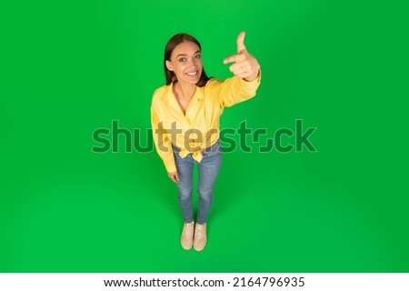 High Angle Shot Of Happy Woman Pointing Finger At Camera Choosing You Standing Over Green Background In Studio. My Choice Concept. Above View, Full Length Royalty-Free Stock Photo #2164796935