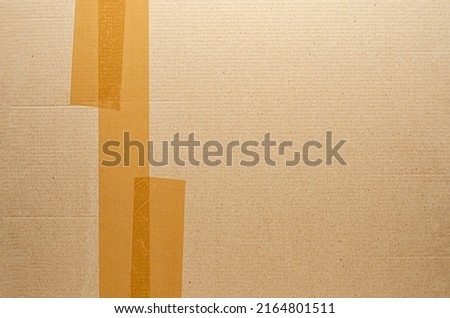 Brown tape on cardboard. The concept of transporting things, sending a donation or packing parcels. Copy space.