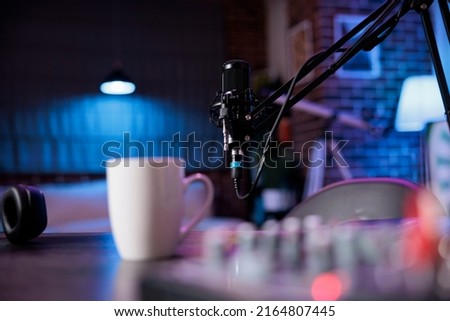 Empty space with podcast equipment to record talking show at home. No people in living room used for online vlogging and broadcasting conversation with microphone, sound production. Royalty-Free Stock Photo #2164807445