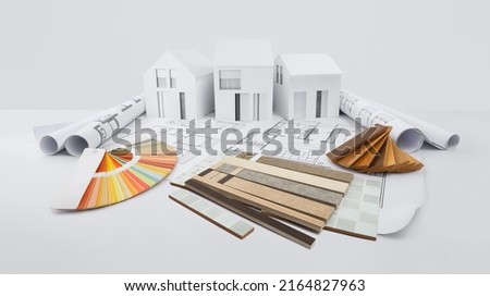 samples of marble tiles with sampler of wooden baseboards and colors swatches, on blueprint drawing with model of houses, interior design, finishing design shop, house materials planning and sale Royalty-Free Stock Photo #2164827963