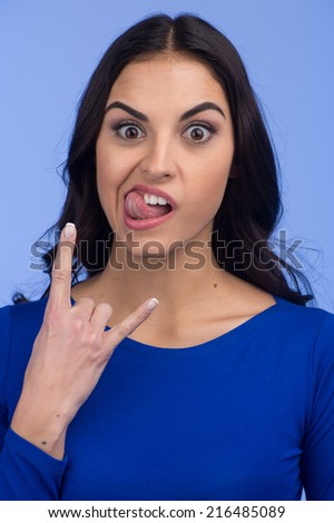 Closeup portrait of adorable young girl. picture of happy girl showing horns gesture 
