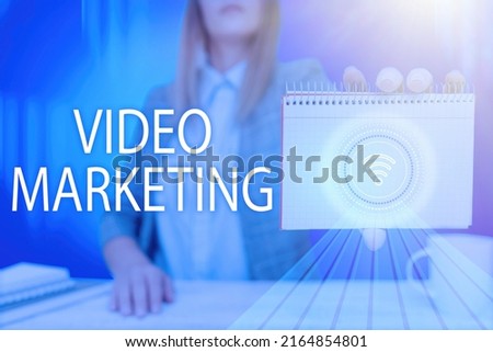 Hand writing sign Video Marketing. Business idea create short videos about specific topics using articles Lady Pressing Screen Of Mobile Phone Showing The Futuristic Technology