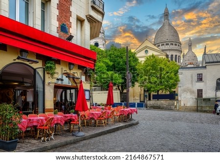 Cozy street with tables of cafe in Montmartre in Paris, France. Architecture and landmarks of Paris. Postcard of Paris Royalty-Free Stock Photo #2164867571