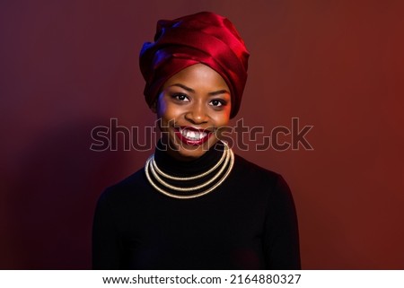 Portrait of attractive cheerful woman wearing traditional look outfit isolated over dark red maroon color background