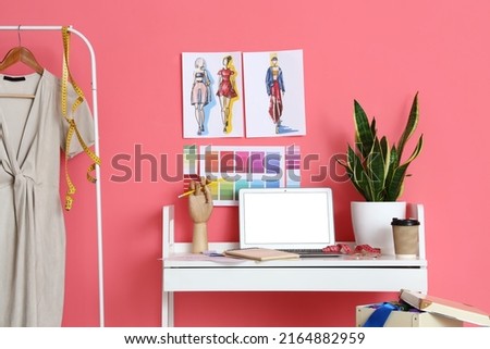Workplace of clothes stylist near pink wall