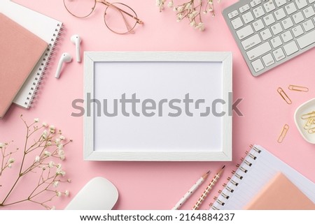 Business concept. Top view photo of workplace photo frame keyboard computer mouse notebooks clips pencils glasses earbuds white gypsophila flowers on isolated pastel pink background with copyspace