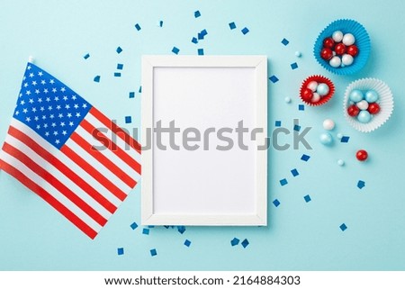 USA Independence Day concept. Top view photo of photo frame national flag paper backing molds with candies and confetti on isolated pastel blue background with blank space