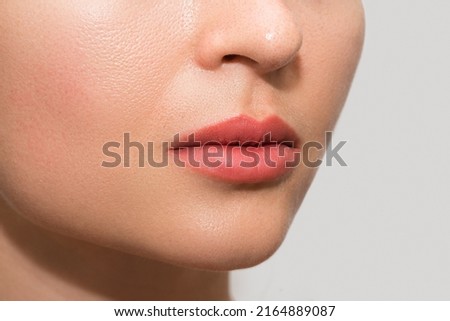 Closeup of female lips after permanent makeup lip blushing procedure Royalty-Free Stock Photo #2164889087