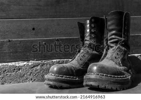 a pair of old dusty leather punk boots without laces, closeup black and white photo