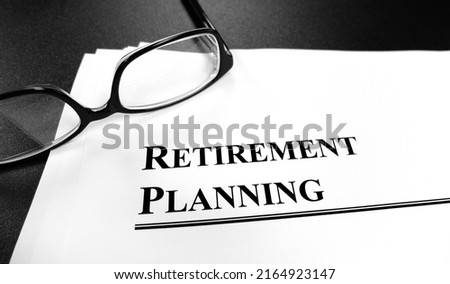 Retirement planning documents on desk with glasses for plan to retire