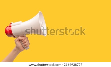 Megaphone in woman hands on a white background.  Copy space.  Royalty-Free Stock Photo #2164938777