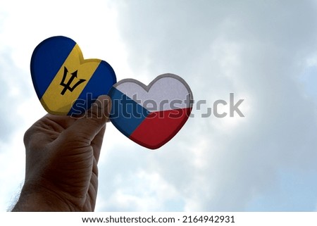 Hand holds a heart Shape Barbados and Czech Republic flag, love between two countries