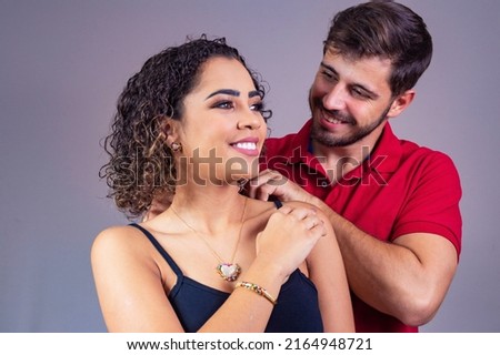 Handsome man wearing necklace on his attractive young woman. happy valentines day concept