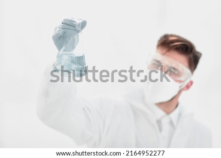 modern scientist examining the liquid in the flask.