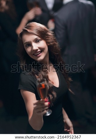 happy young woman raising a glass of champagne