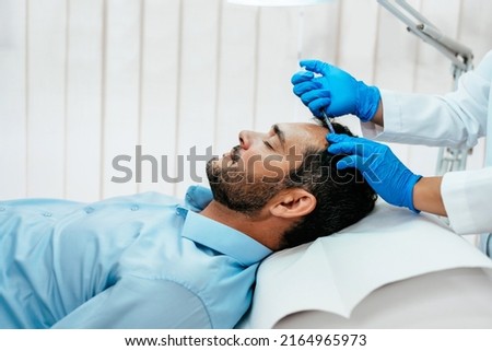 Handsome middle age man receiving advanced Platelet Rich Plasma PRP treatment against hair loss. Modern aesthetics treatments for males. Healthcare and beauty concept. Royalty-Free Stock Photo #2164965973