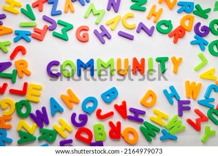 Group of colored letters forming in the center the word "community" on a white background.