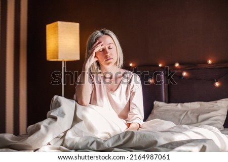 After sleepless night sad 40s woman got up sit on bed thinking, lost in sad thoughts about irreparable mistake decision about abortion, feeling remorse, break up in relations, divorce and jealousy  Royalty-Free Stock Photo #2164987061