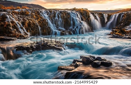 Scenic image of Iceland. Incredible nature landscape. Stunning view of Bruarfoss Waterfall. Azure water flows over stones. Bright midnight sun of Iceland. Iceland is a most popular place of travel. 