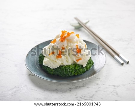 Sauteed Scallops with Scrambled Egg White in Truffle Oil served in a dish side view on grey background