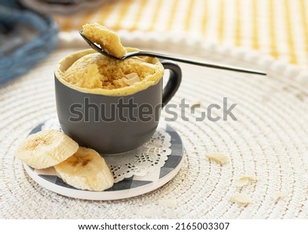 mini cake. Breakfast in a mug. selective focus. homemade Portioned Banana mugcake in small mugs. Easy sweet baking in the microwave idea, With fresh bananas, nuts. Muffin with banana slices cooked  Royalty-Free Stock Photo #2165003307