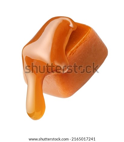 Caramel sauce flowing on caramel cube isolated on white background. Caramel candy with liquid caramel. Royalty-Free Stock Photo #2165017241